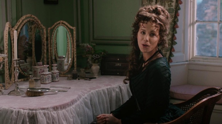 Kate Beckinsale as Lady Susan Vernon speaking while sitting by a dressing table and looking to her right in Love & Friendship